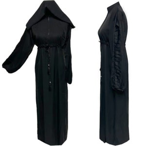 May include: A black abaya with a long sleeve, a hood, and a drawstring waist. The sleeves have a ruffled detail.