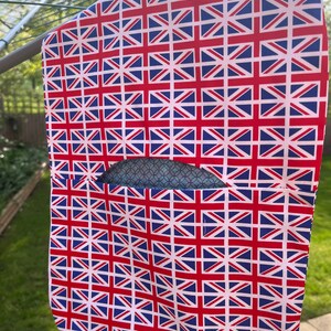 Pode incluir: Uma bolsa de roupa branca com um padr&atilde;o Union Jack. A bolsa tem uma pequena abertura para um cabide.