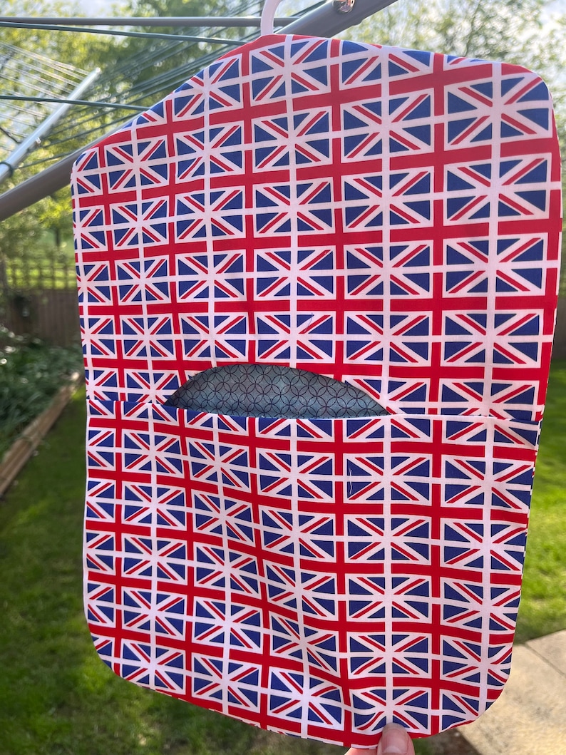 Pode incluir: Uma bolsa de roupa branca com um padr&atilde;o Union Jack. A bolsa tem uma pequena abertura para um cabide.