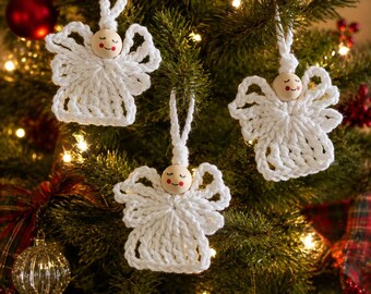 May include: Three handmade white crochet angel ornaments hanging on a Christmas tree. Each angel features a round wooden bead head with a painted face, including closed eyes, a small smile, and rosy cheeks, attached to a white crocheted body.