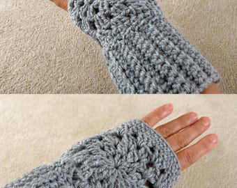 May include: A pair of light grey fingerless gloves crafted with a crochet technique. The design features a circular granny square pattern on the back of the hand, transitioning into a ribbed cuff that extends down to cover the wrist area.