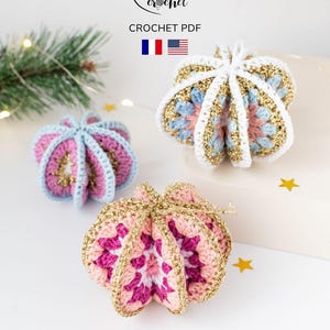 Peut inclure: Trois ornements de Noël crochetés à la main en rose, bleu et blanc avec des accents dorés. Les ornements ont un design en forme d'éclat d'étoile. L'image comprend le texte "zess crochet" et "CROCHET PDF".