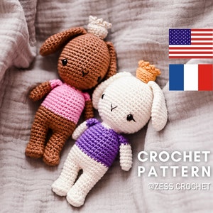 May include: Two crocheted bunny amigurumi toys with crowns, one brown with a pink shirt and one white with a purple shirt, on a gray textured fabric background. The text "CROCHET PATTERN @ZESS.CROCHET" is below the bunnies.