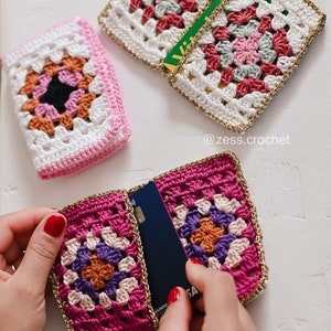 Puede incluir: Un porta tarjetas de ganchillo con ribete dorado y un dise&ntilde;o de cuadrado de la abuela colorido. El porta tarjetas est&aacute; abierto y se puede ver una tarjeta de cr&eacute;dito en el interior.