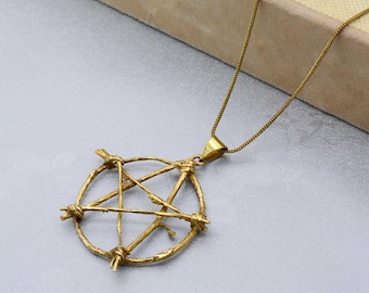 May include: A gold chain necklace with a pentagram pendant. The pendant is made of twisted wire and has a circular shape.