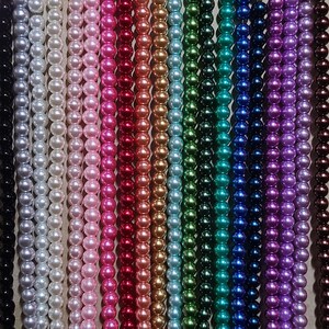May include: A collection of beaded strands in a variety of colors, including black, silver, white, pink, red, gold, green, blue, purple, and brown. The beads are uniform in size and appear to be pearls, creating a visually appealing display.