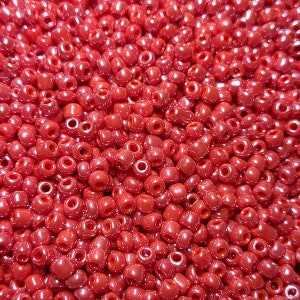 May include: A close-up image of a large quantity of small, red, round beads. The beads are arranged in a random pattern, creating a textured surface.