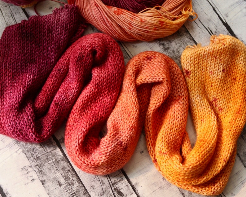 Peut inclure: Trois &eacute;charpes circulaires en tricot dans des tons de rouge, orange et jaune. Les &eacute;charpes sont faites d'un fil doux et textur&eacute; et sont parfaites pour ajouter une touche de chaleur et de couleur &agrave; n'importe quelle tenue.