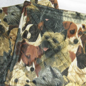 May include: Set of three brown and beige quilted pot holders featuring a pattern of various dog breeds.