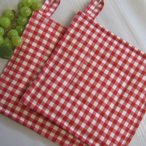 May include: Two red and white gingham pot holders with a loop handle.