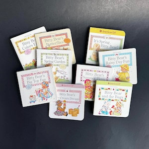 May include: A collection of small, colorful children's books featuring the "Bitty Bear" character. Titles include "Colors," "Butterflies," "Spring Garden," "Big Top Fun," "Cream Dream," "It's Spring," "Summer Picnic," "Rainy Day Fun," and "and the Bugs."