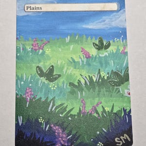 May include: A rectangular trading card featuring a hand-painted landscape of a green meadow with purple wildflowers under a blue sky. The word Plains is printed in a white bar at the top, and the initials SM are visible in the bottom right corner.