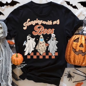 May include: Black t-shirt with a retro design featuring three ghosts wearing face masks and the text "Hanging with my boos".