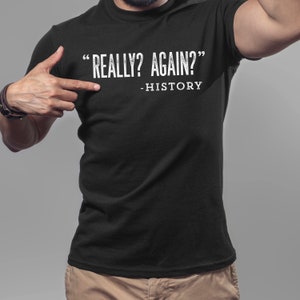 May include: Black t-shirt with white text that reads "REALLY? AGAIN?" - HISTORY