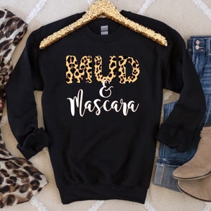 May include: Black sweatshirt with a leopard print design that says "MUD & Mascara" in white text.