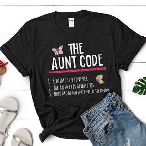 Peut inclure: T-shirt noir avec du texte blanc qui dit "THE AUNT CODE" et une liste de règles : "1. BEDTIME IS WHENEVER 2. THE ANSWER IS ALWAYS YES 3. YOUR MOM DOESN'T NEED TO KNOW".