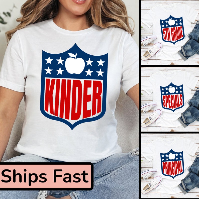 May include: White t-shirt with a blue and red shield design featuring a white apple and the word "kinder" in red letters. The shield has white stars on a blue background. The t-shirt is being modeled by a person wearing blue jeans.