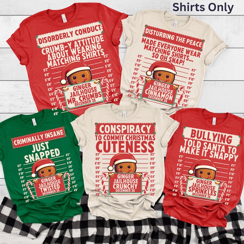May include: A collection of Christmas-themed t-shirts in red, green, and cream colors. Each shirt features a gingerbread man design with a Santa hat and candy cane accents, along with humorous text. The shirts are displayed on a black and white checkered surface.