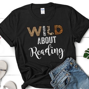 May include: Black t-shirt with the text "WILD ABOUT Reading" in white. The word "WILD" is made up of animal print letters.