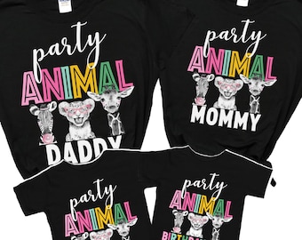 Könnte beinhalten: Vier schwarze T-Shirts mit einem Party-Tier-Motiv. Die Shirts zeigen ein Zebra, einen Löwen und eine Giraffe mit dem Text "Party Animal" in Pink, Grün und Gelb. Die Shirts sind mit "Papa", "Mama", "Geburtstags Mädchen" und "Schwester" beschriftet.