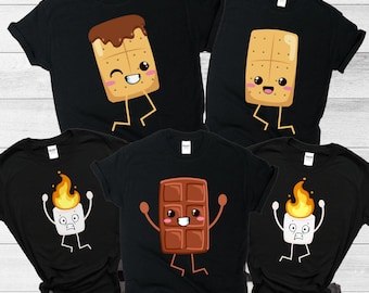 May include: Black t-shirts with cartoon graphics of s'mores ingredients. Designs include a graham cracker with chocolate and marshmallow, a chocolate bar, and a marshmallow with flames. The shirts are perfect for camping or a fun, matching outfit.