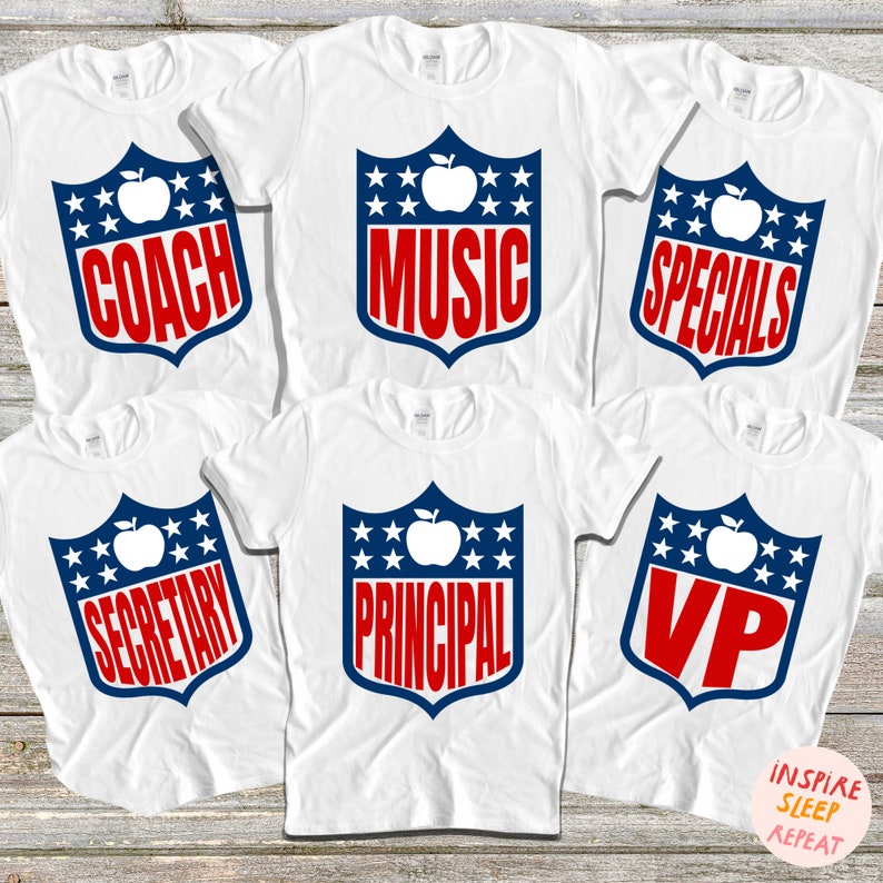 May include: Six white t-shirts with a blue and red shield design featuring a white apple and text. The text on the shirts reads "Coach", "Music", "Specials", "Secretary", "Principal", and "VP".
