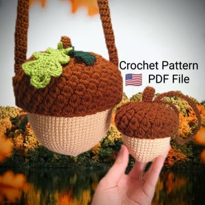 Puede incluir: Patrón de crochet en archivo PDF para hacer dos juguetes amigurumi con forma de bellota. La bellota más grande tiene una hoja verde en la parte superior y una combinación de colores marrón y beige. La bellota más pequeña es marrón y beige.