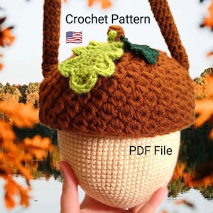 May include: Crocheted acorn-shaped bag with a brown top and beige bottom. The bag features a green and yellow leaf design and a brown strap. Text on the image reads "Crochet Pattern" and "PDF File".