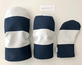 May include: Three golf head covers in a navy blue and white striped pattern. The largest cover is for a driver, the middle cover is for a wood, and the smallest cover is for a putter.