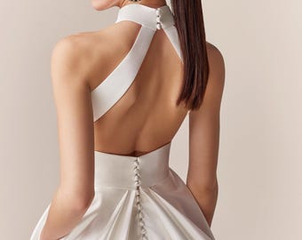 Halter top Crepe Ball Gown Wedding Dress. Minimalist Halter Neck White Gown. The bodice is form-fitting. Asymmetrical Pleating bridal dress