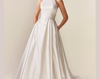 Halter top Crepe Ball Gown Wedding Dress. Minimalist Halter Neck White Gown. The bodice is form-fitting. Asymmetrical Pleating bridal dress