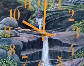May include: A clock face with Roman numerals painted on a rocky landscape with a waterfall flowing down the center. The clock hands are gold.