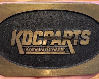 Vintage KDC Parts Komatsu-dressoirriemgesp – promogesp voor zwaar materieel – industrieel verzamelobject