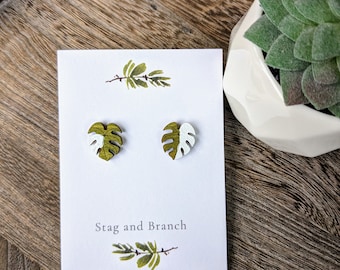 May include: A pair of white and green monstera leaf earrings on a white card with the text "Stag and Branch".