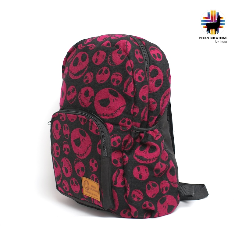 K&ouml;nnte beinhalten: Ein schwarzer Rucksack mit einem pinkfarbenen und schwarzen Muster von Jack Skellingtons Gesicht aus Nightmare Before Christmas. Der Rucksack hat eine Rei&szlig;verschlusstasche auf der Vorderseite und eine kleine Tasche an der Seite. Der Rucksack hat einen schwarzen verstellbaren Riemen.