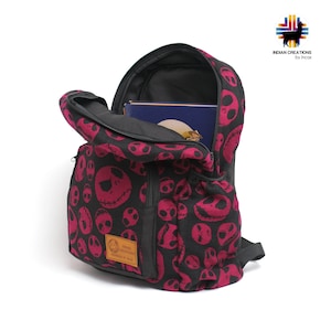 K&ouml;nnte beinhalten: Ein schwarzer Rucksack mit einem pink-schwarzen Muster von Jack Skellingtons Gesicht aus Nightmare Before Christmas. Der Rucksack hat eine Rei&szlig;verschlusstasche vorne und ein gro&szlig;es Hauptfach. Der Rucksack ist aus einem weichen, strapazierf&auml;higen Stoff gefertigt.