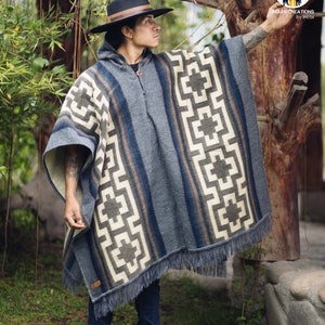 May include: A gray alpaca wool poncho with a geometric pattern and fringe. The poncho is worn by a person wearing a black hat and blue jeans. The poncho has a label that says "Indian Creations by Incas".