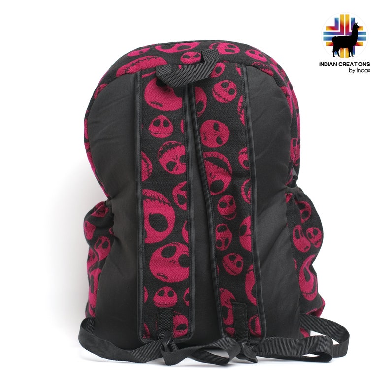 K&ouml;nnte beinhalten: Ein schwarzer Rucksack mit verstellbaren Tr&auml;gern. Der Rucksack besteht aus einem schwarzen Stoff mit einem pinkfarbenen und schwarzen Muster von Jack Skellingtons Gesicht aus dem Film Nightmare Before Christmas.
