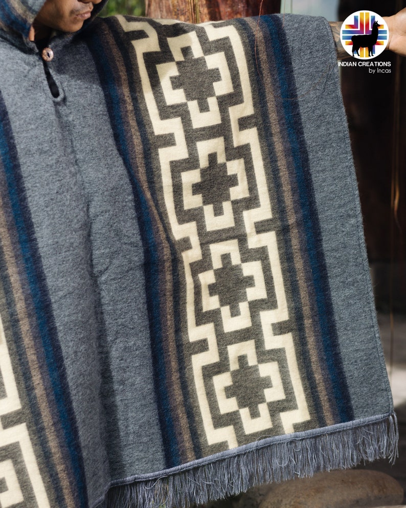 May include: Gray hooded poncho with a geometric pattern in white, brown, and blue. The poncho has a fringe border.