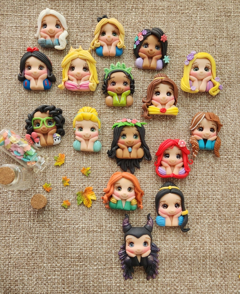 May include: A collection of 15 handmade polymer clay Disney princess character charms. Each charm features a different princess with a unique expression and pose. The charms are perfect for adding a touch of magic to jewelry, crafts, and other projects.