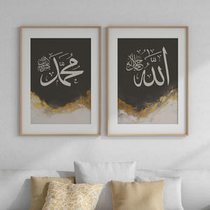 Puede incluir: Dos impresiones enmarcadas con fondos negros y acentos dorados. Las impresiones presentan caligrafía árabe, una con la palabra "Allah" y la otra con la frase "Muhammad, el Mensajero de Allah".