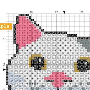 May include: A cross-stitch pattern featuring a cat's face. The design uses a grid of squares with various colors, including pink, gray, black, and gold. The word "example" is in a yellow box in the upper left corner.