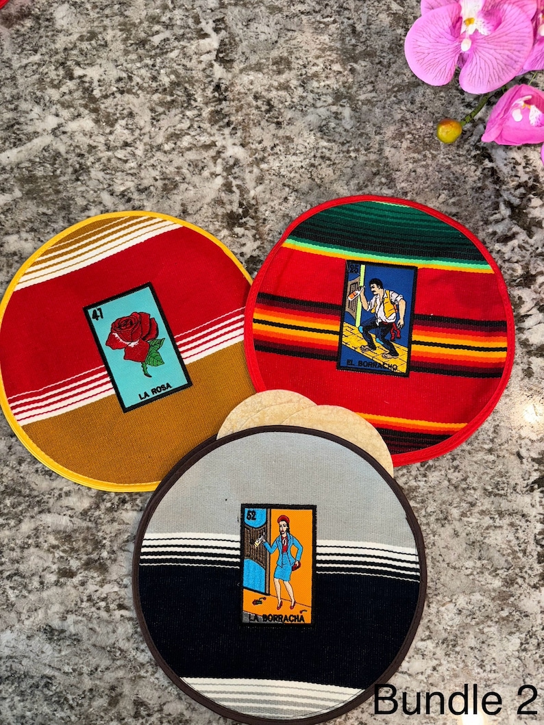 K&ouml;nnte beinhalten: Set aus drei runden, bunten Stoffuntersetzern mit mexikanischem Design. Jeder Untersetzer zeigt eine andere Loteria-Karte mit einer bunten Illustration und Text. Die Karten sind "La Rosa", "El Borracho" und "La Borracha".