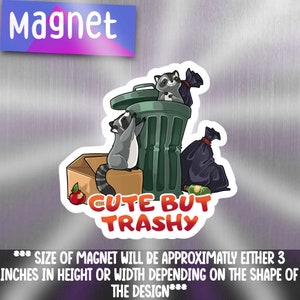 May include: A cute magnet featuring two raccoons in a green bin with a black bin bag and a red apple. The text "CUTE BUT TRASHY" is written in orange and black letters. The magnet is approximately 3 inches in height or width.
