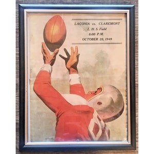 May include: A vintage framed poster advertising a football game between Laconia and Claremont. The poster features a red and white football player catching a brown football. The game is scheduled for October 28, 1949 at L.H.S. Field at 8:00 P.M.