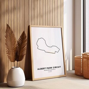 Peut inclure: Une impression encadr&eacute;e du circuit automobile d'Albert Park &agrave; Melbourne, en Australie. La piste est dessin&eacute;e en noir sur un fond blanc. Le texte "ALBERT PARK CIRCUIT" est imprim&eacute; en noir sous la piste, avec l'emplacement "MELBOURNE, AUSTRALIA" et la longueur "5.303 KM" imprim&eacute;s en texte noir plus petit en dessous.