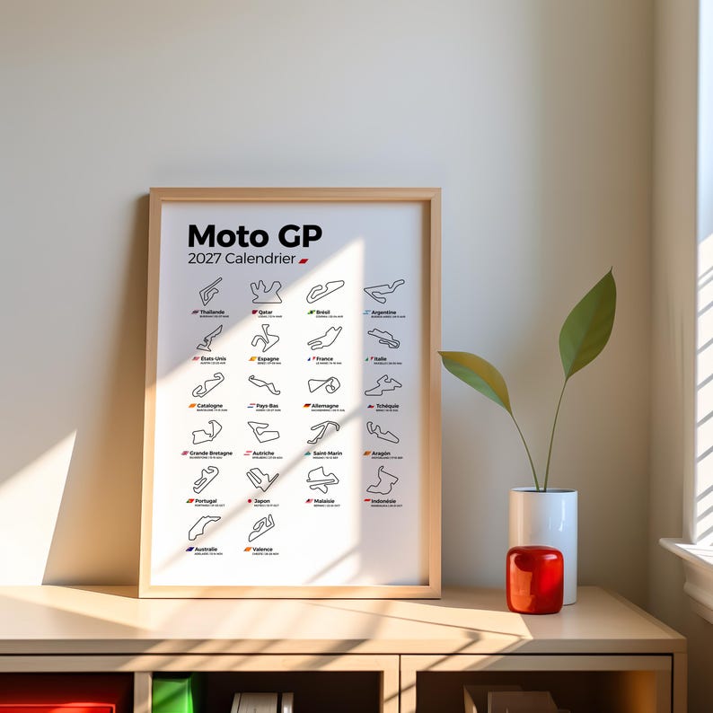 K&ouml;nnte beinhalten: Ein gerahmtes Poster mit dem Titel Moto GP 2027 Calendrier, das ein Raster aus schwarzen Linienzeichnungen verschiedener Motorradrennstrecken zeigt, jeweils beschriftet mit dem L&auml;ndernamen und einer kleinen Flagge auf wei&szlig;em Grund.