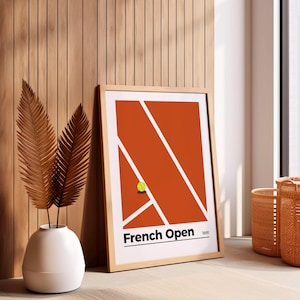 May include: A framed print of a tennis court with a single tennis ball on the red clay surface. The print has the text "French Open 1891" at the bottom.