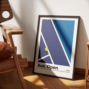 May include: A black framed poster with a blue and purple abstract design of a tennis court. A yellow tennis ball is on the court. The poster says "Aus. Open 1905".