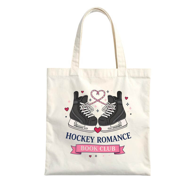 Puede incluir: Bolso tote color crema con un dise&ntilde;o de dos patines de hielo negros con cordones blancos y un coraz&oacute;n rosa. El texto "HOCKEY ROMANCE BOOK CLUB" est&aacute; en una pancarta rosa debajo de los patines, con peque&ntilde;os corazones y estrellas.